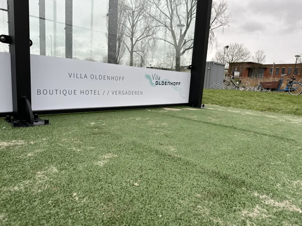 PadelReclame - Dubbelzijdige lage stickers op een padelbaan met sponsoring bij vereniging HV Abcoude.