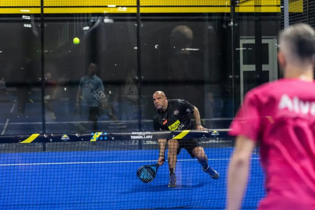 Andy van der Meijde bij Peakz Padel Zwolle met een gepersonaliseerde netbandcover van PadelReclame.